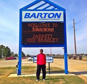 Senior Jarrett Cox-Bradley stands in front of a sign at Barton CC welcoming him on his visit. Photo courtesy of Cox-Bradley.