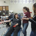 Senior Jamie David and junior Elizabeth Berson chat with junior Sophie Wennemann so she stays calm during the blood drive. (Photo by Lauren Sparks)