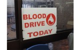 A sign hangs against a rainy window just days before the blood drive donation. Students near this sign got to sign up at the table to donate.