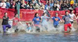 Teenagers plunge into Creve Coeur Lake during a previous year’s Polar Plunge. This year's theme is fiesta, and costumes are suggested. 